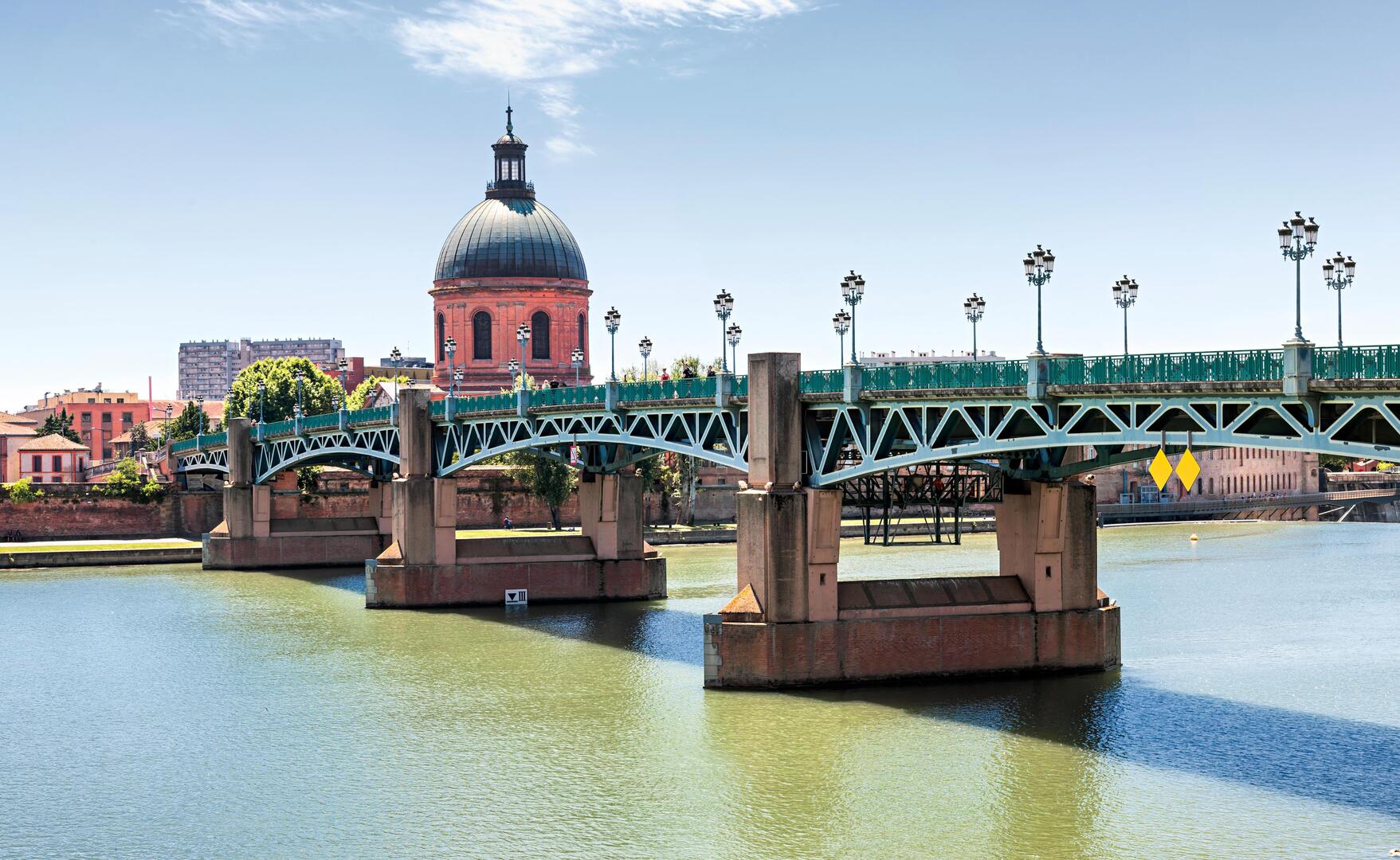 Panoramic view of Saint-Pierre Bridge in Toulouse, France, with the Dome de la Grave in the background.