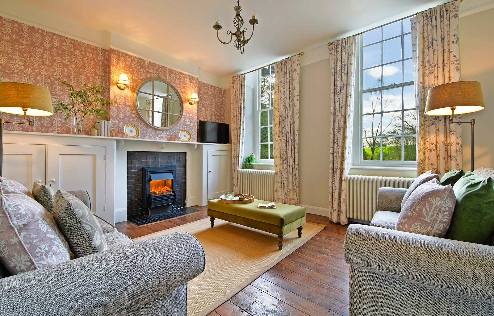 Cozy living room with fireplace and patterned wallpaper.