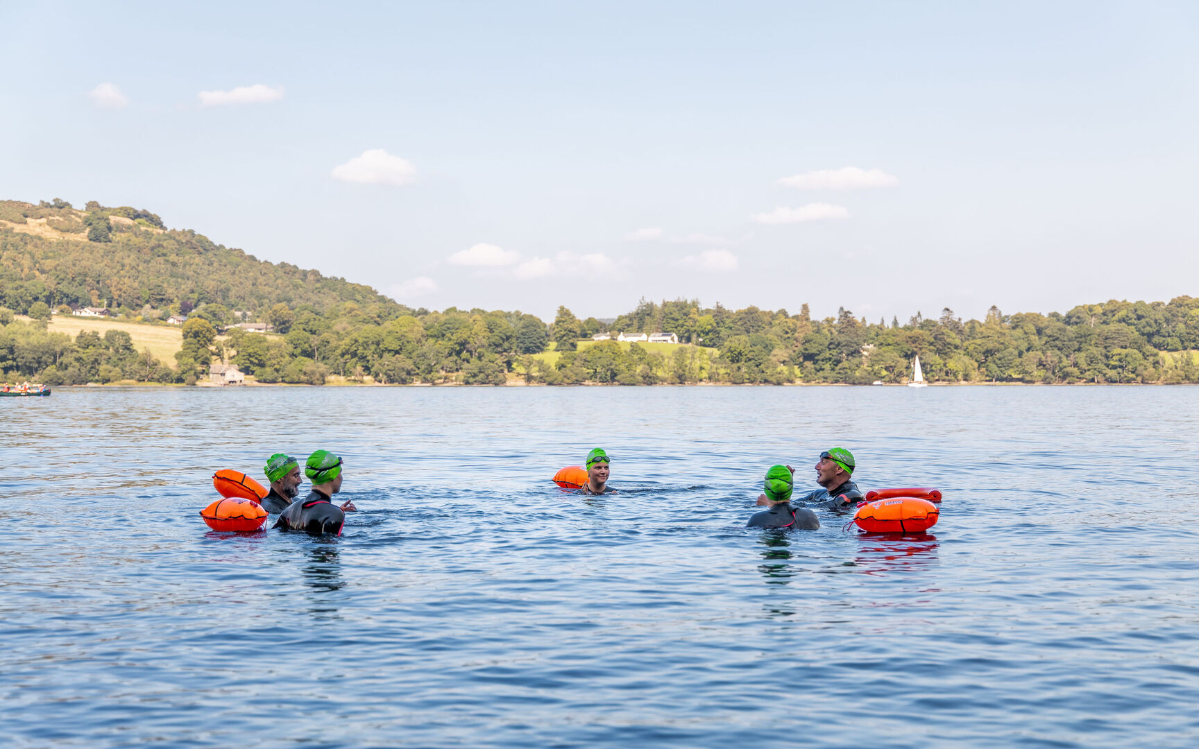 Swimmers in a lake using flotation devices.