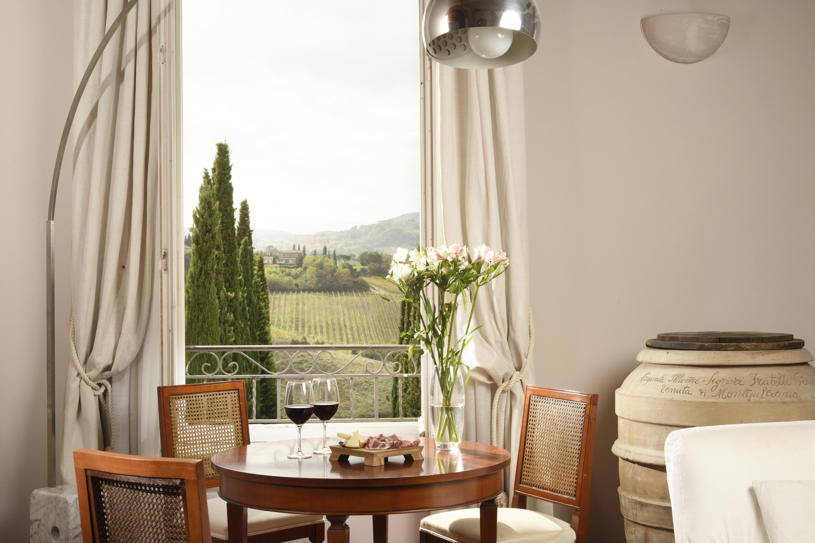 A scenic table setting with wine and cheese overlooking a vineyard.