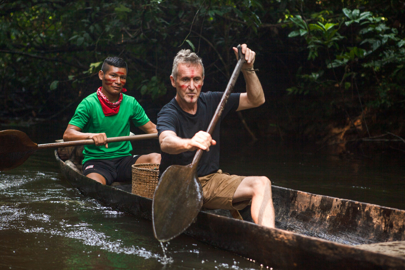 Two men canoeing down a river in the Colombian Amazon.