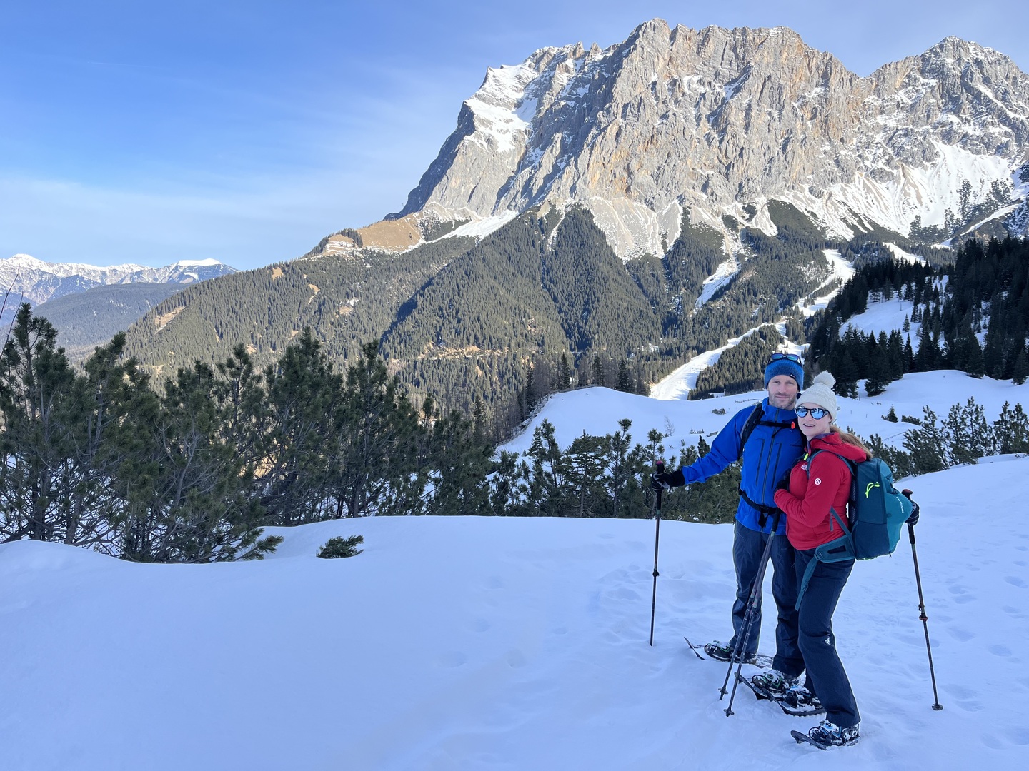 Couple snowshoeing in Ehrwald, Austria, with mountains in the background.